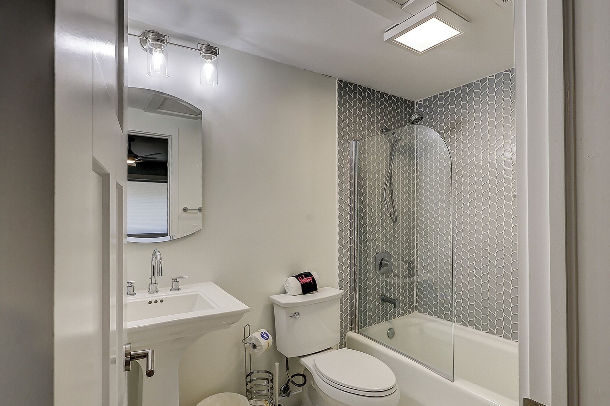 A bathroom with a sink, toilet, and shower.
