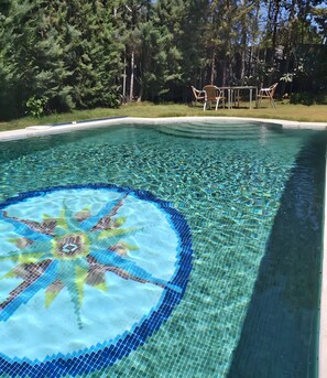 A swimming pool with a mosaic design, surrounded by trees and outdoor furniture. - Rural House 'La Saucedilla' with Mountain Views, Private Pool and Wi-Fi (Archidona)