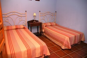 A room with two beds, a nightstand, and a lamp. - Rural House 'La Saucedilla' with Mountain Views, Private Pool and Wi-Fi (Archidona)