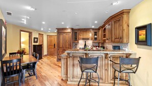 Una cocina con armarios de madera, encimera de granito y un comedor con mesa y sillas.