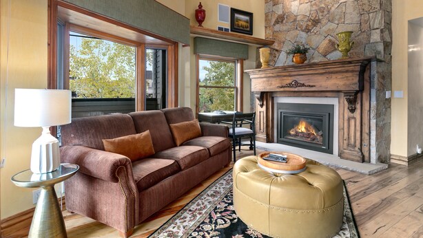 Una sala de estar con chimenea, sofá, mesa de centro y lámpara.