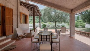 An outdoor patio with a table set for dining, surrounded by chairs, and a pergola overhead. - Nice home in Configni (Configni)