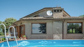 A two-story building with a swimming pool, large windows, and a satellite dish. - Nice home in Configni (Configni)