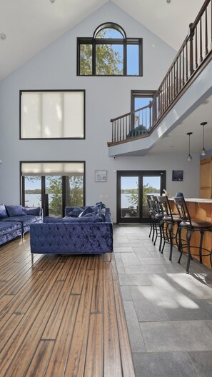 A spacious living area with a large window, a staircase, and a seating area with a view of the outdoors. - Rochester Lakeview 4br With Firepit Sleeps 6 4 Bedroom Home (Rochester)