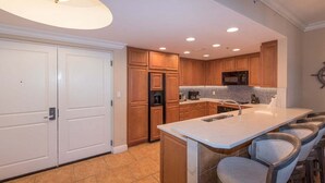 Una cocina moderna con armarios de madera, una isla grande y un microondas integrado.