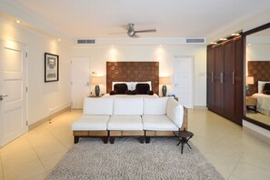 Ein Schlafzimmer mit einem Bett, einem weißen Sofa, einem Deckenventilator und einem Kleiderschrank.