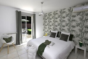 Ein Schlafzimmer mit Bett, Sessel, Nachttisch und einem Fenster mit Vorhängen.