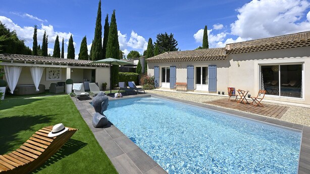 A swimming pool with lounge chairs, a patio area, and a building with a tiled roof. - Villa des Amis with jacuzzi and swimming pool near the Alpilles and Luberon mountains (Sorgues)
