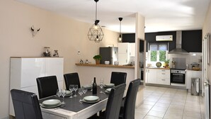 A modern kitchen with white cabinets, a dining table set for four, and a black chandelier. - Villa des Amis with jacuzzi and swimming pool near the Alpilles and Luberon mountains (Sorgues)