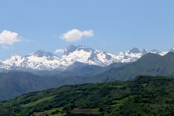A mountainous landscape with snow-capped peaks and lush green valleys.