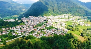 Vista aérea de un pueblo con edificios residenciales, carreteras y zonas verdes circundantes.