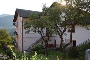 Een gebouw met twee verdiepingen, een balkon, een trap en een tuin.