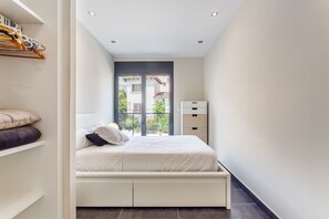 Un dormitorio con cama, ventana, armario y calentador.