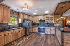 Eine moderne Küche mit Holzschränken, Edelstahlgeräten und einer Steinrückwand.