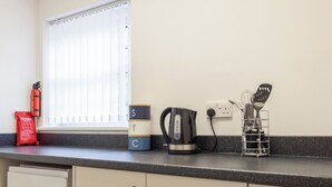 Een keukenblad met een koffiezetapparaat, een brandblusser en een branddeken.