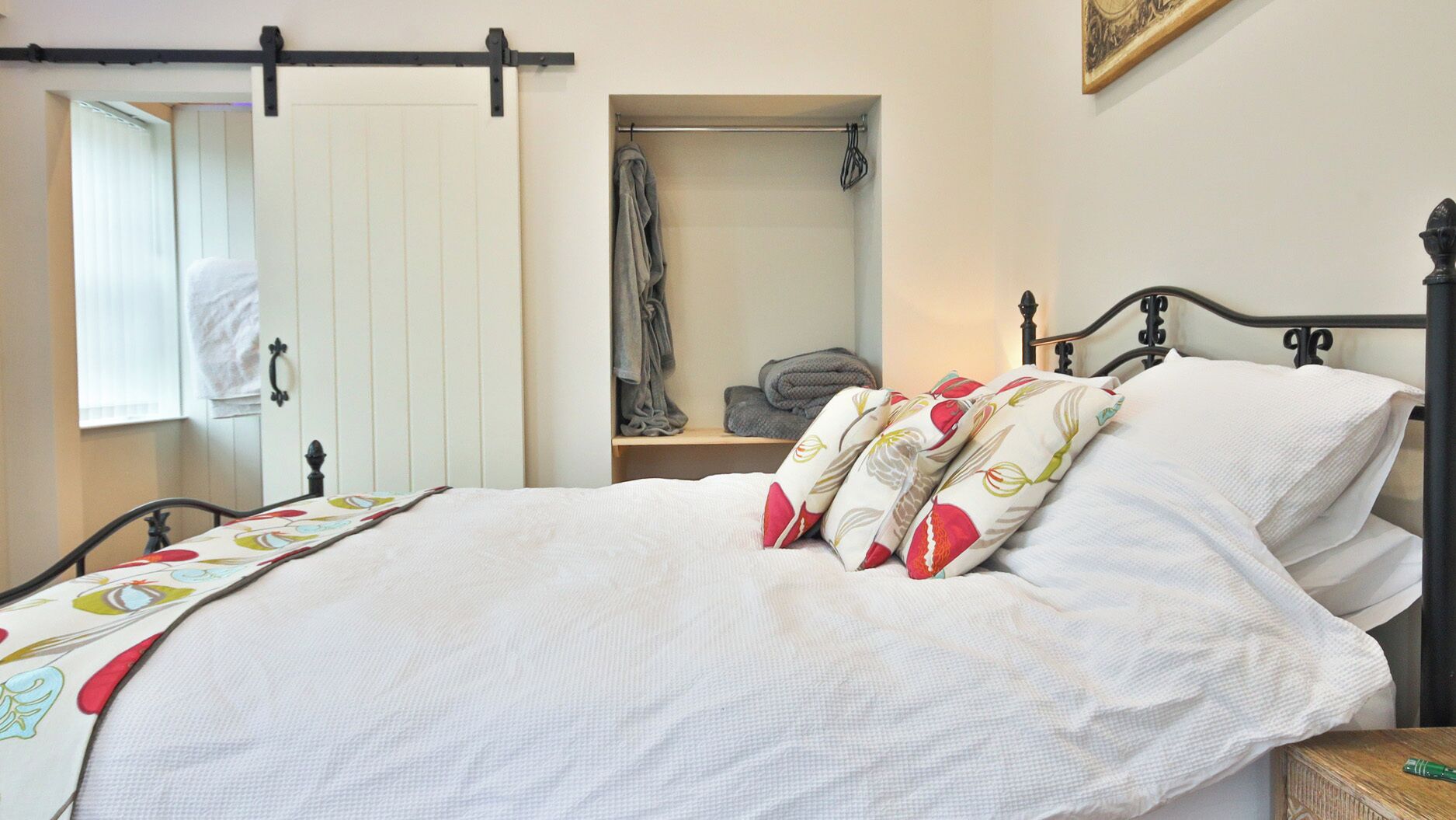 A bedroom with a bed, a wardrobe, and a window.