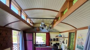 A compact kitchen with a central island, bar stools, and a refrigerator. - Beautiful custom tiny home 20 min from Middlebury! (Addison)
