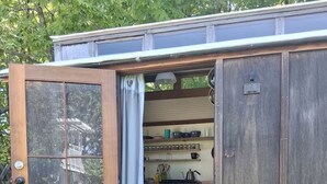 A wooden cabin with a large open door leading to a kitchen area. - Beautiful custom tiny home 20 min from Middlebury! (Addison)