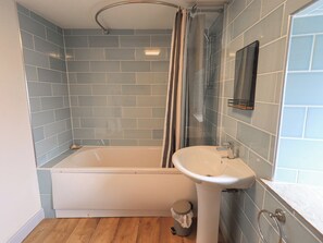 Ein Badezimmer mit einer Badewanne, einem Waschbecken und einer Duschvorhang.