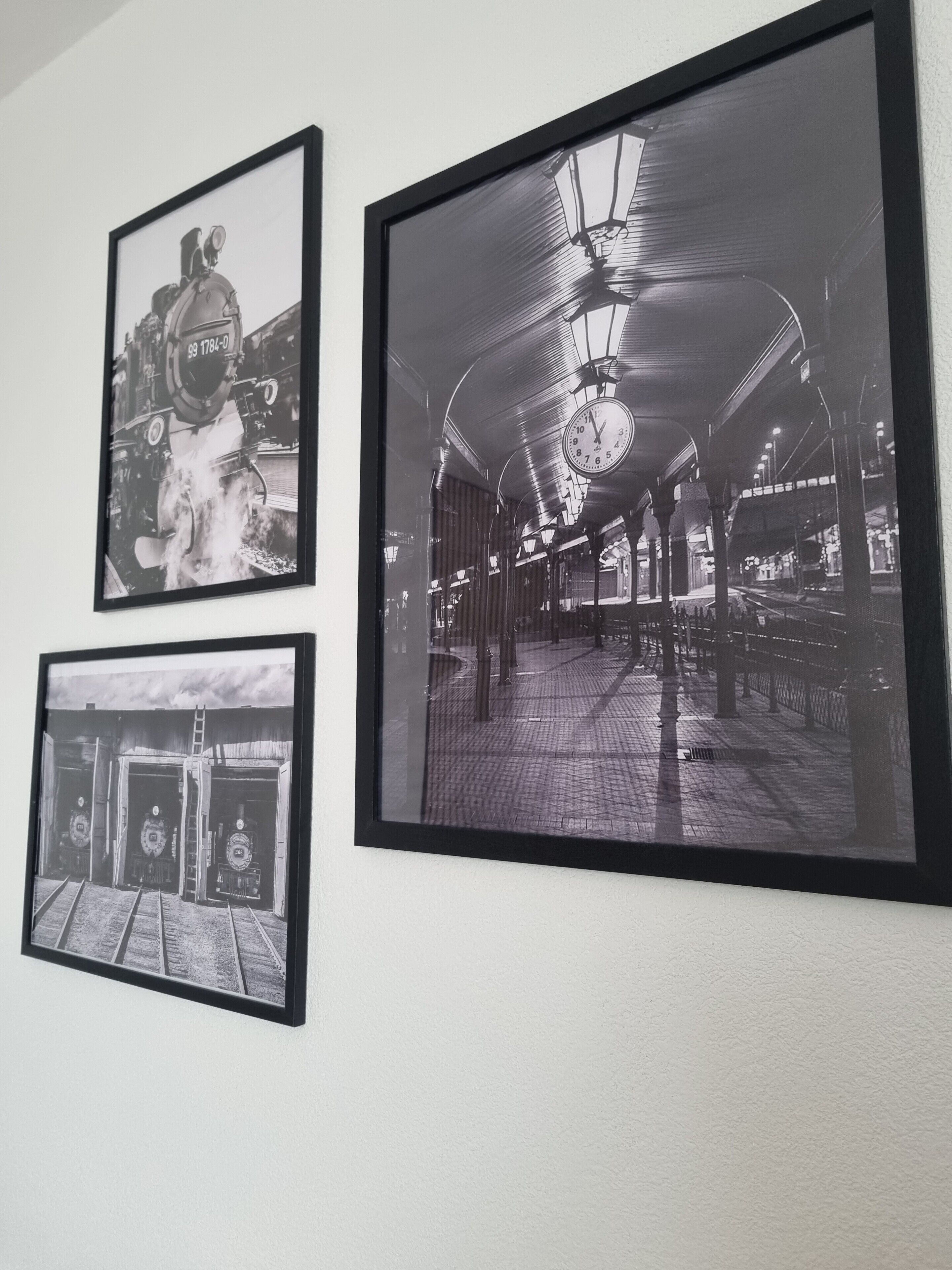 Three black and white photographs of a train station interior, including a clock, platform, and train tracks.