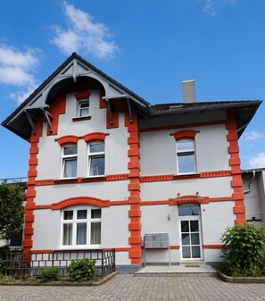 A multi-story building with a symmetrical facade, large windows, and a central entrance.