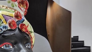 Una escultura con rostro negro, patrones coloridos y diseño geométrico.