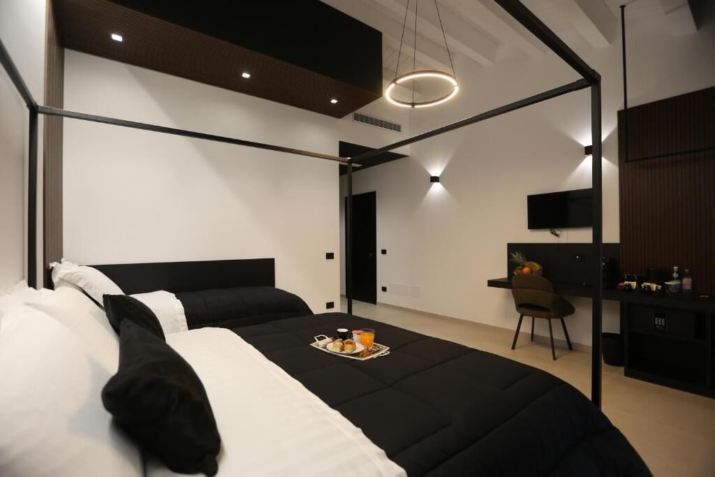 A modern hotel room with a bed, a desk, and a chair.