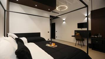 A modern hotel room with a bed, a desk, and a chair.
