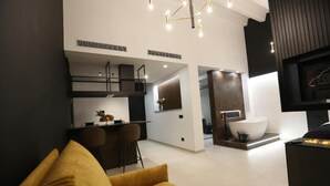 Un interior moderno con cocina, comedor y una bañera blanca grande.