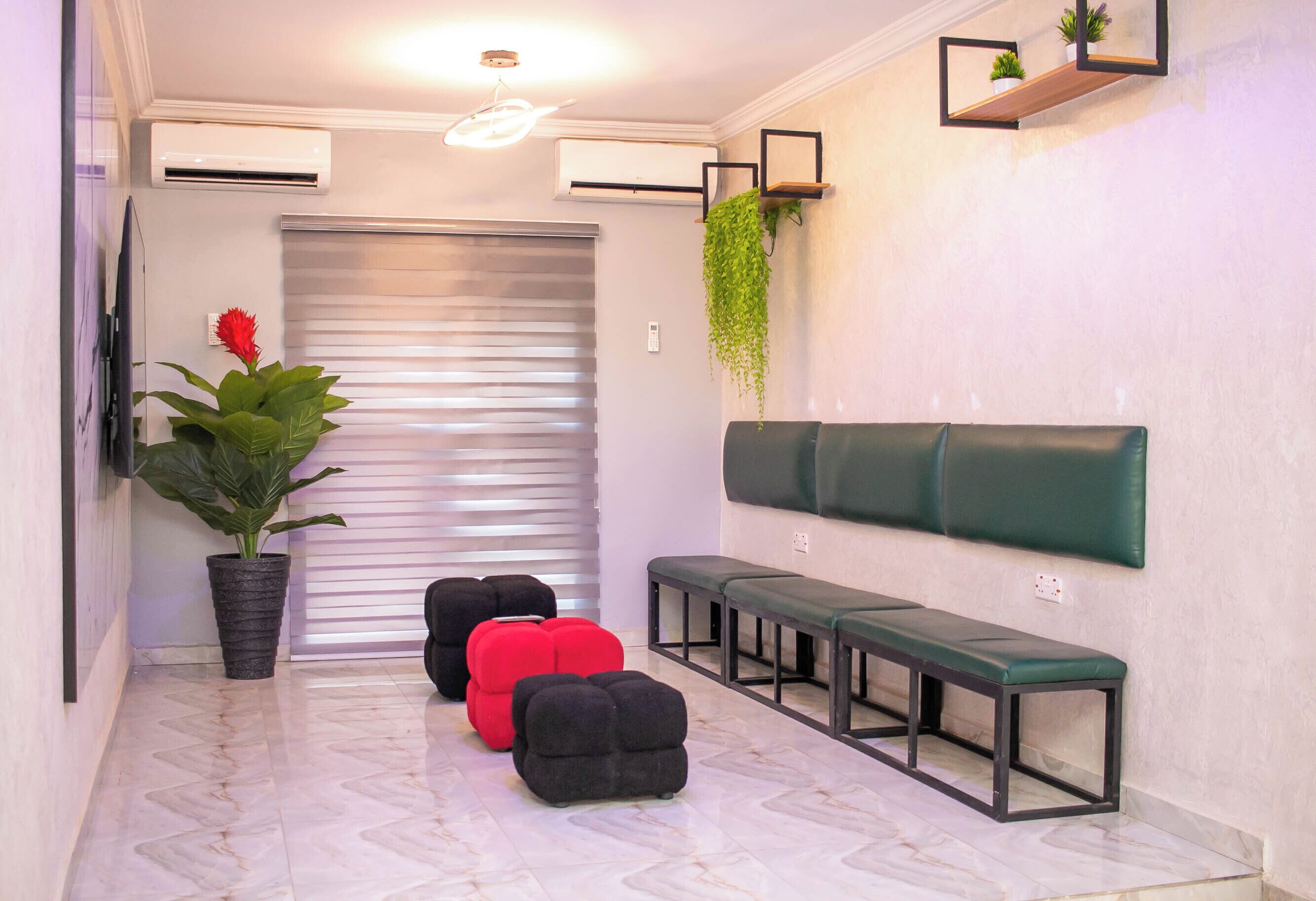 A hallway with a potted plant, a bench, and a wall-mounted shelf with a plant.