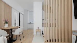 Ein modernes Zimmer mit Essbereich, einem kleinen Nachttisch und einer Holzwand.