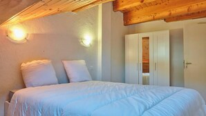 Ein Schlafzimmer mit einem Bett, zwei Kissen, einem Kleiderschrank und einer Tür.