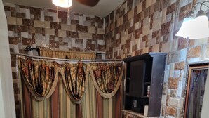 Ein Badezimmer mit Duschvorhang, Toilette, Waschbecken und Fliesen.