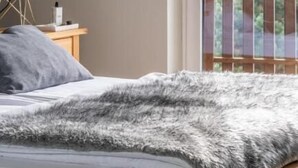 Una camera da letto con un letto, un comodino, una lampada e vista sulle montagne da una finestra.