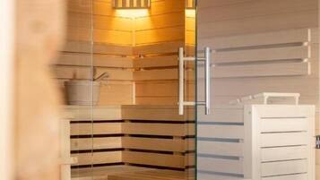 Una sauna con paredes de madera, una puerta de cristal y un banco.