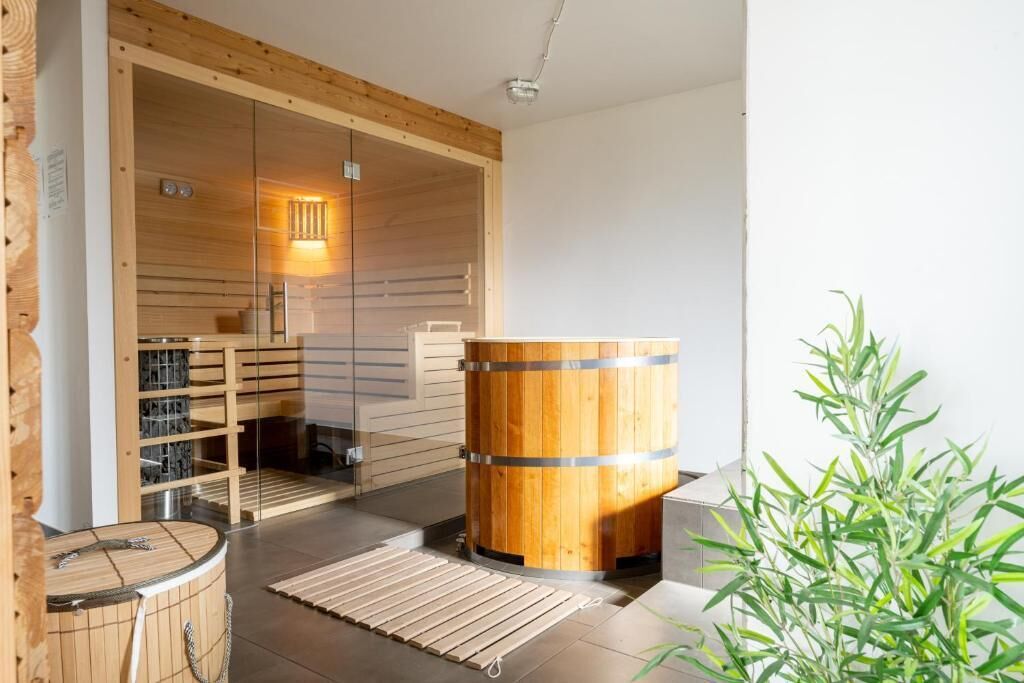 A sauna room with wooden walls, a large wooden barrel, and a small table.