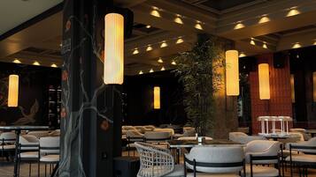 L’intérieur d’un restaurant, avec un mobilier moderne, des luminaires suspendus et des œuvres d’art décoratives sur les murs.