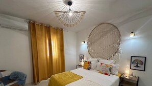 Une chambre à coucher avec un lit, des rideaux, une décoration murale, une table de chevet et une chaise.