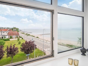 A coastal view from a window overlooking a road, beach, and residential area. - 4 Person Holiday Home in Hejls (Hejls)