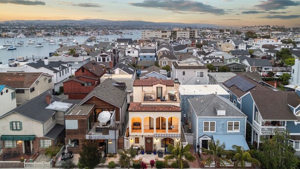 Una zona residencial costera con un puerto deportivo, casas con balcones y una vista despejada del agua.
