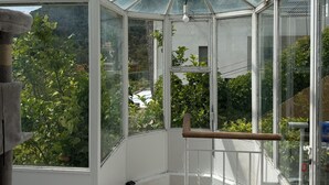 A greenhouse with a glass roof, wooden floor, and a view of greenery outside. - Petite Eze (Provence-Alpes-Côte d'Azur)