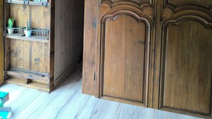 A wooden wardrobe with a mirror, a shelf with decorative items, and a wooden floor. - "La Maison Nomade" vacation rental in a paradise-like setting. Woods. Ponds. Very quiet (CHAGNY)
