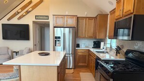 Una cocina moderna con armarios de madera, electrodomésticos de acero inoxidable y una isla central.