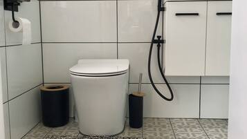 A bathroom with a toilet, bidet, and sink.