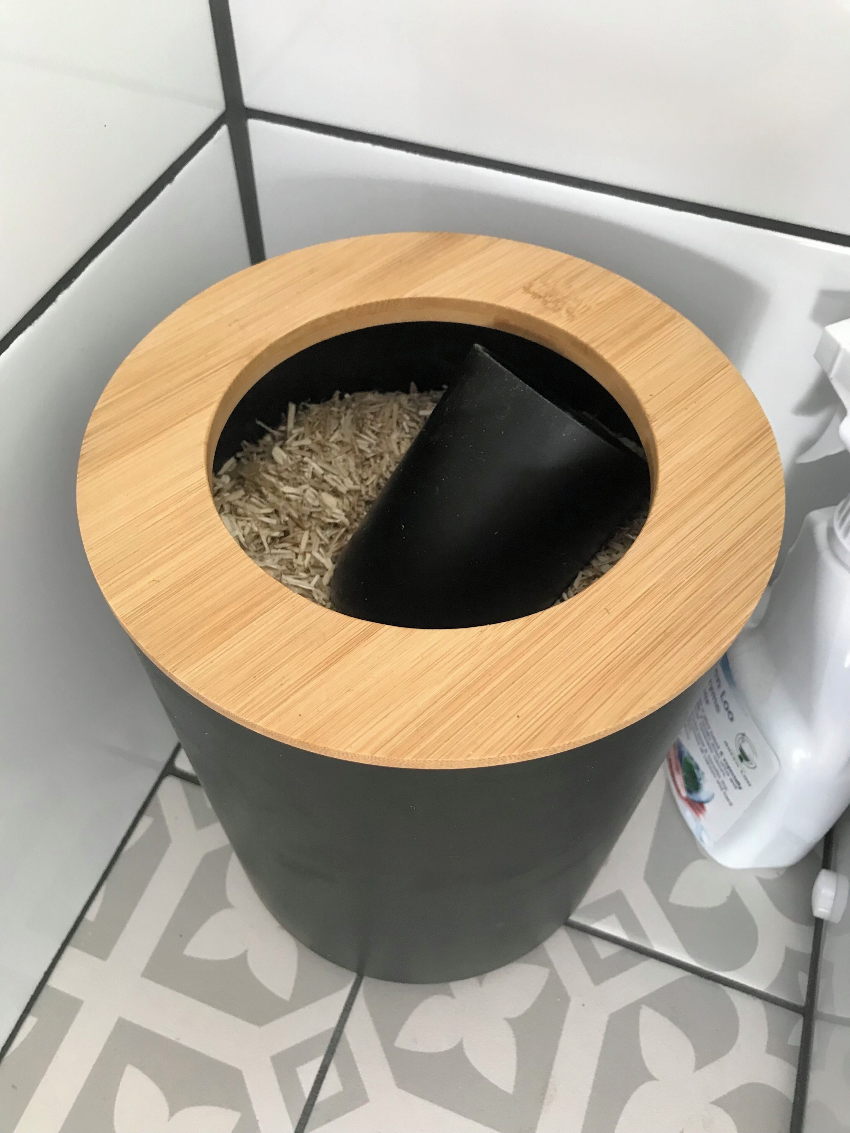 Un cubo de basura con abertura circular y parte interior negra.