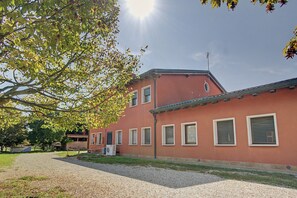 A building with multiple windows and a gravel driveway.