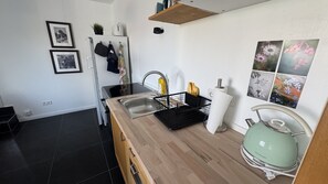 Eine moderne Küche mit Holzarbeitsplatte, Edelstahlspüle und Wasserkocher.
