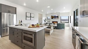 Uma cozinha moderna com ilha central, eletrodomésticos embutidos e área de jantar com vista.