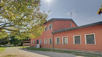 Un edificio con diverse finestre e un vialetto sterrato.