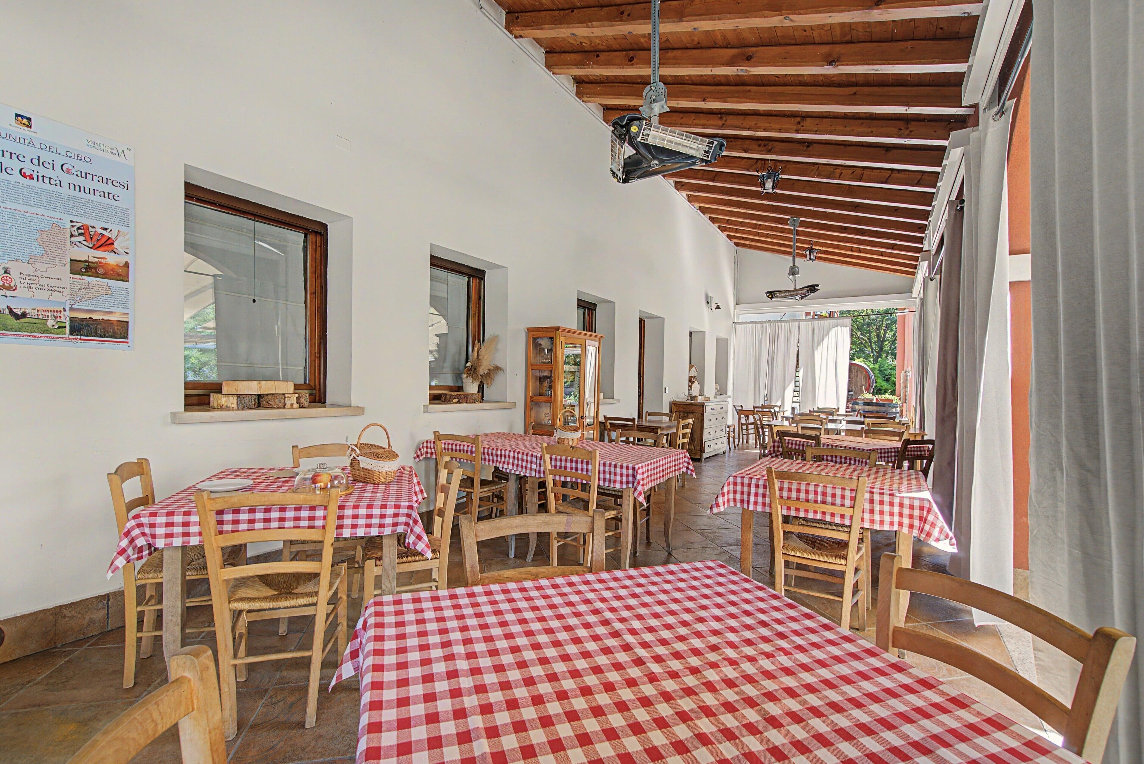 En restaurang med röd- och vitrutiga bordsdukar, trästolar och ett träpanelat tak.